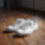 Stylish white sneakers on a wooden floor