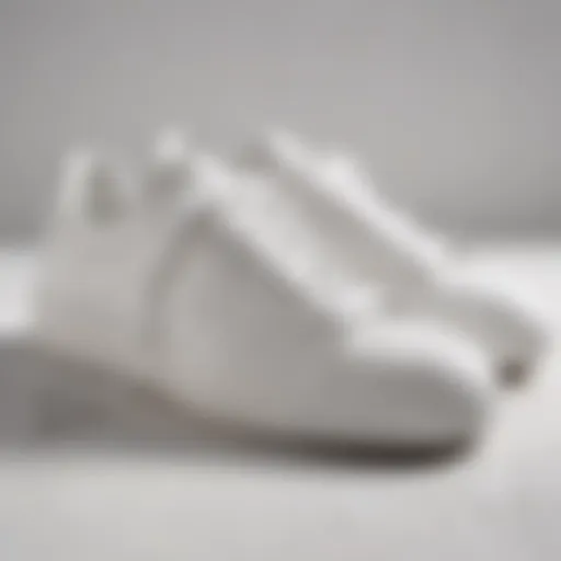 A close-up view of stylish all-white sneakers on a textured surface